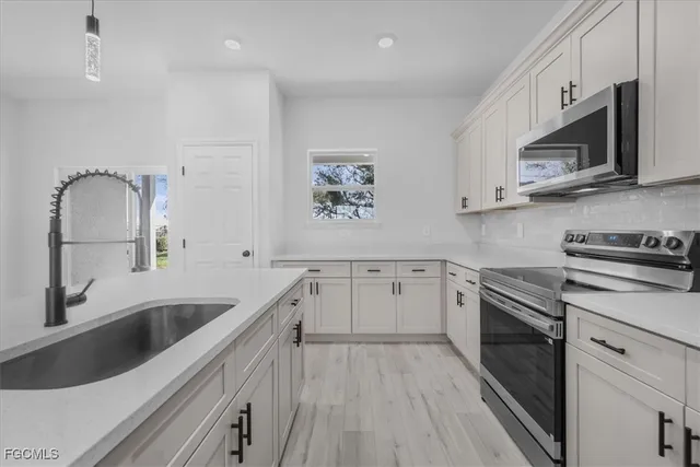 a kitchen with white cabinets and stainless steel appliances