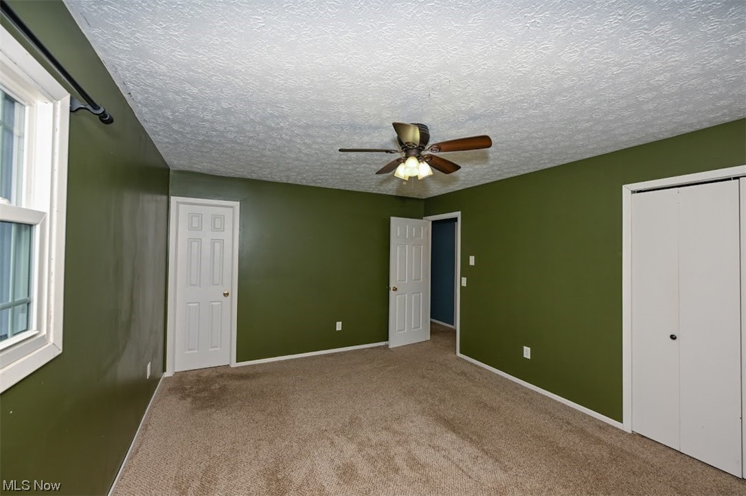 3368 Erhart Road Litchfield, OH 44253 - Photo 24 of 35 Carpeted bedroom featuring a textured ceiling and ceiling fan