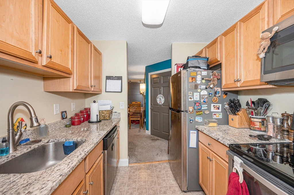 200 Market Street, Unit 3409 Lowell, MA 01852 - Photo 11 of 21 a kitchen with granite countertop a refrigerator stove and sink