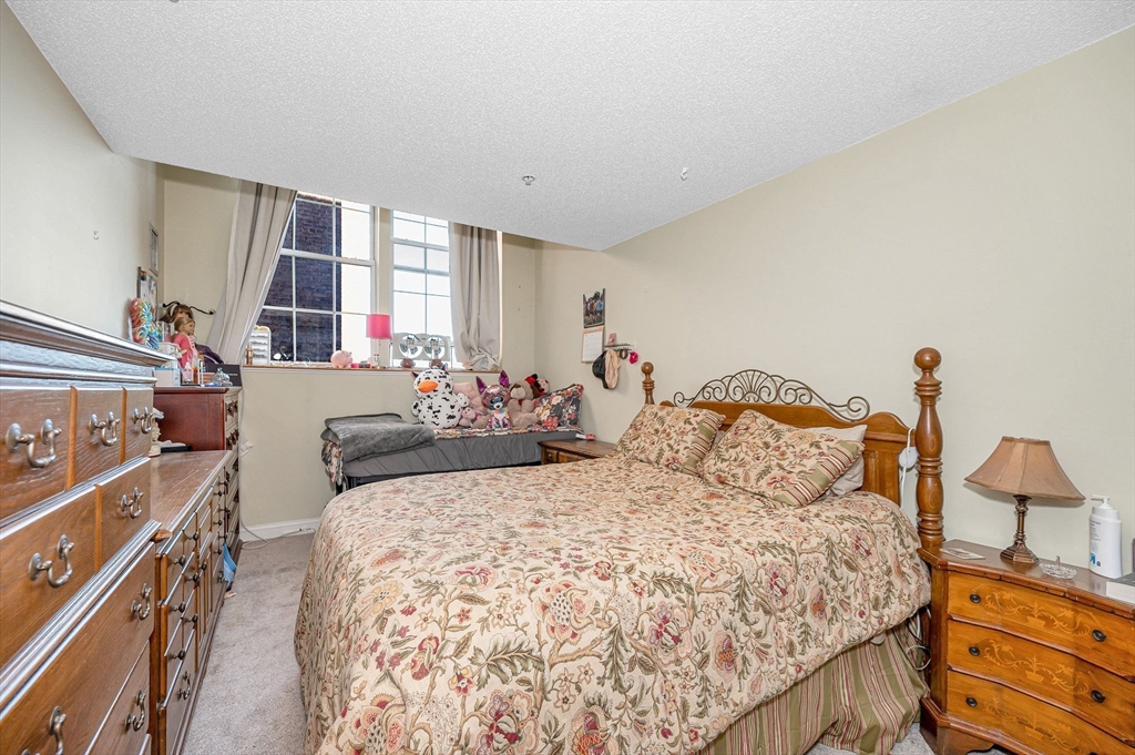 200 Market Street, Unit 3409 Lowell, MA 01852 - Photo 17 of 21 a bed room with a bed and a dresser