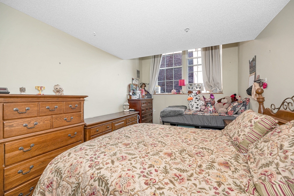 200 Market Street, Unit 3409 Lowell, MA 01852 - Photo 18 of 21 a bedroom with a bed and a dresser