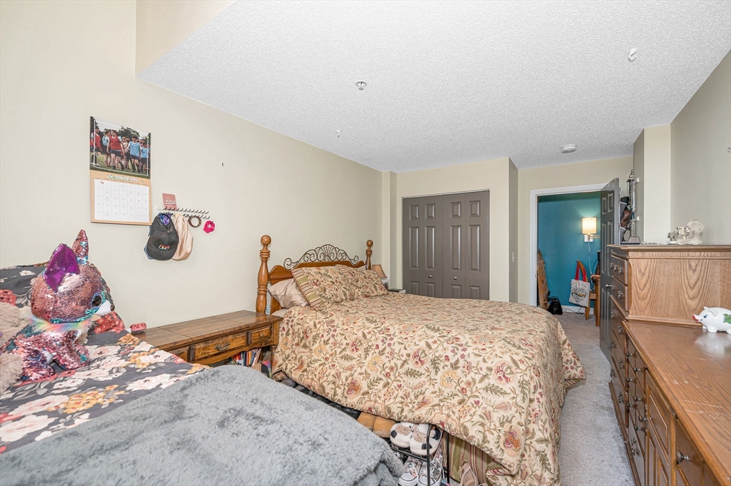 200 Market Street, Unit 3409 Lowell, MA 01852 - Photo 19 of 21 a bedroom with a bed and a dresser