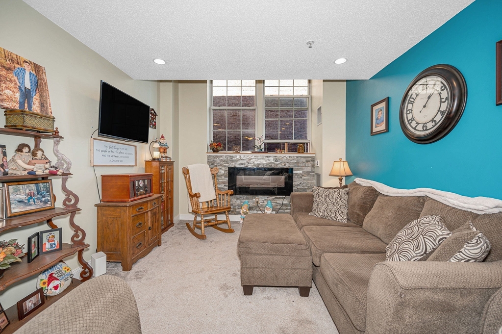 200 Market Street, Unit 3409 Lowell, MA 01852 - Photo 4 of 21 a living room with furniture a large window and a flat screen tv