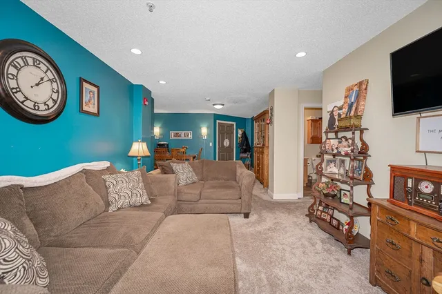 a living room with furniture a clock and a flat screen tv