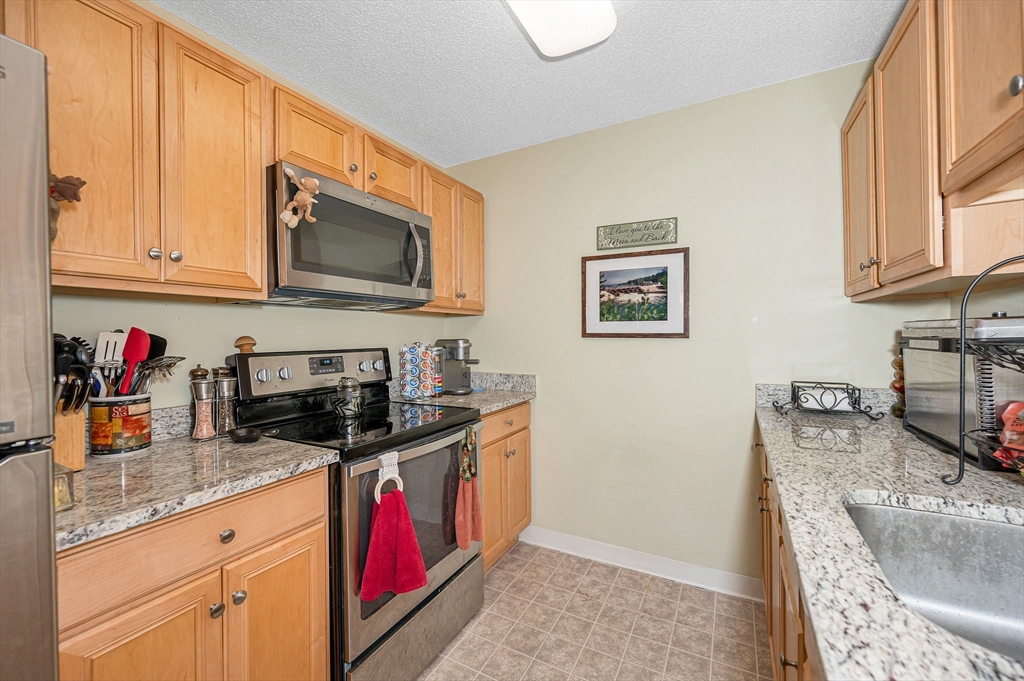 200 Market Street, Unit 3409 Lowell, MA 01852 - Photo 10 of 21 a kitchen with stainless steel appliances granite countertop a stove and a sink