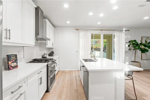 a kitchen with white cabinets and stove