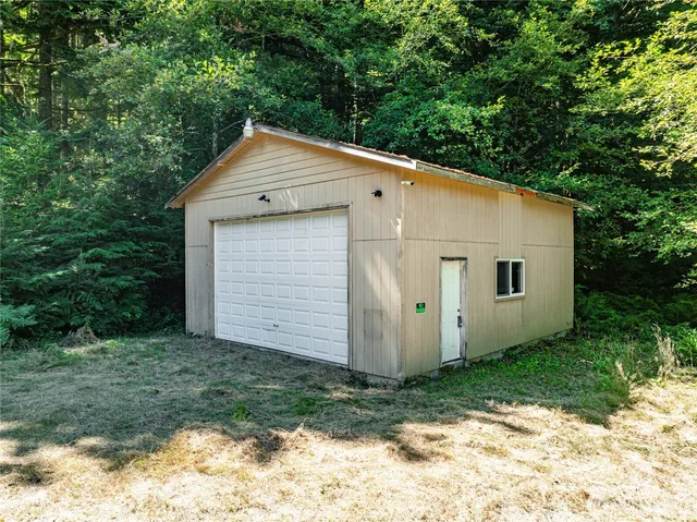 a view of a small house with yard and a tree