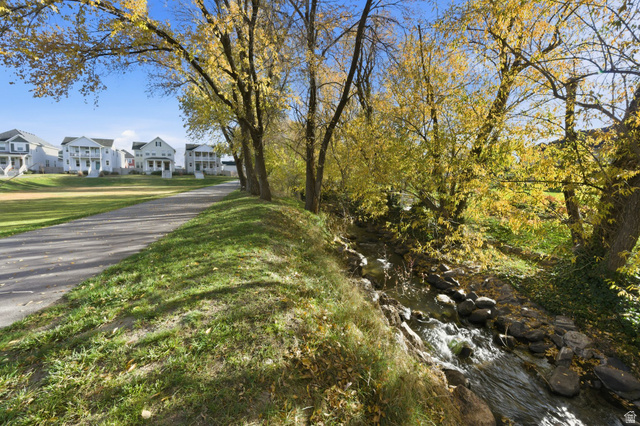 1038 South Old Towne Road Layton, UT 84041 - Photo 31 of 39 Natural creek with flowing water, bordered by mature trees with golden foliage
