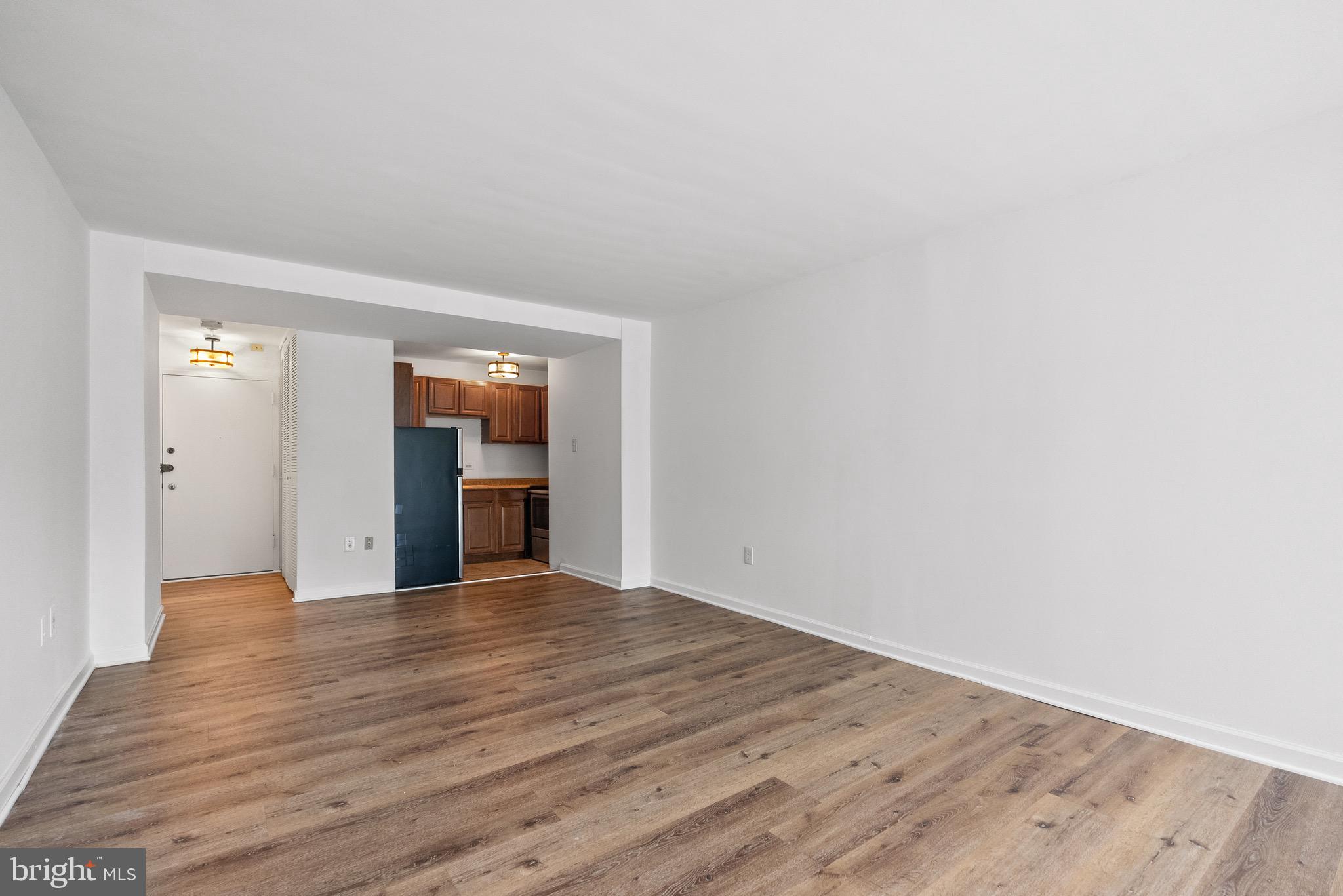 1301 Delaware Avenue Southwest, Unit N108 Washington, DC 20024 - Photo 20 of 39 a view of an empty room with wooden floor and kitchen