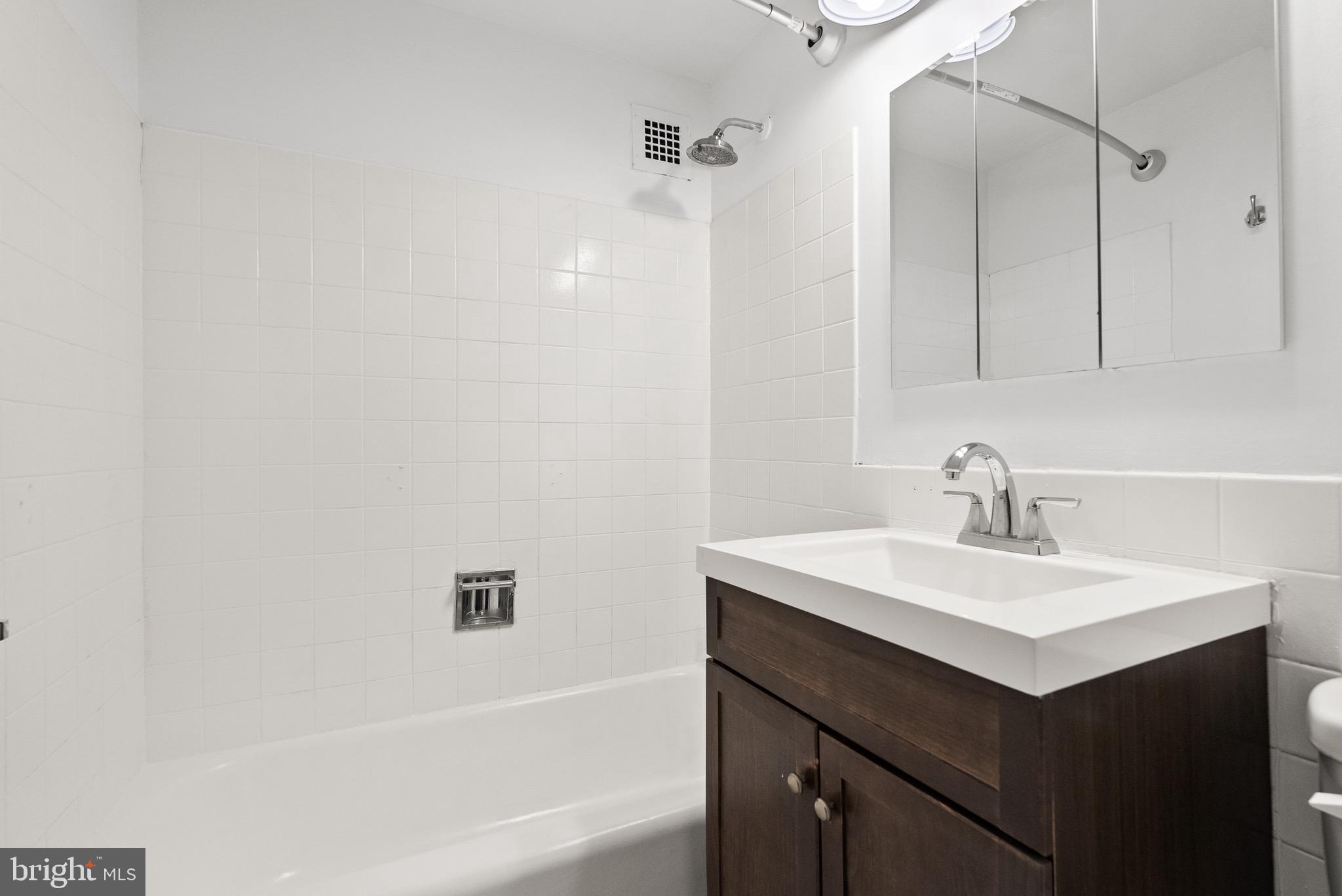 1301 Delaware Avenue Southwest, Unit N108 Washington, DC 20024 - Photo 27 of 39 a bathroom with a sink vanity and a mirror