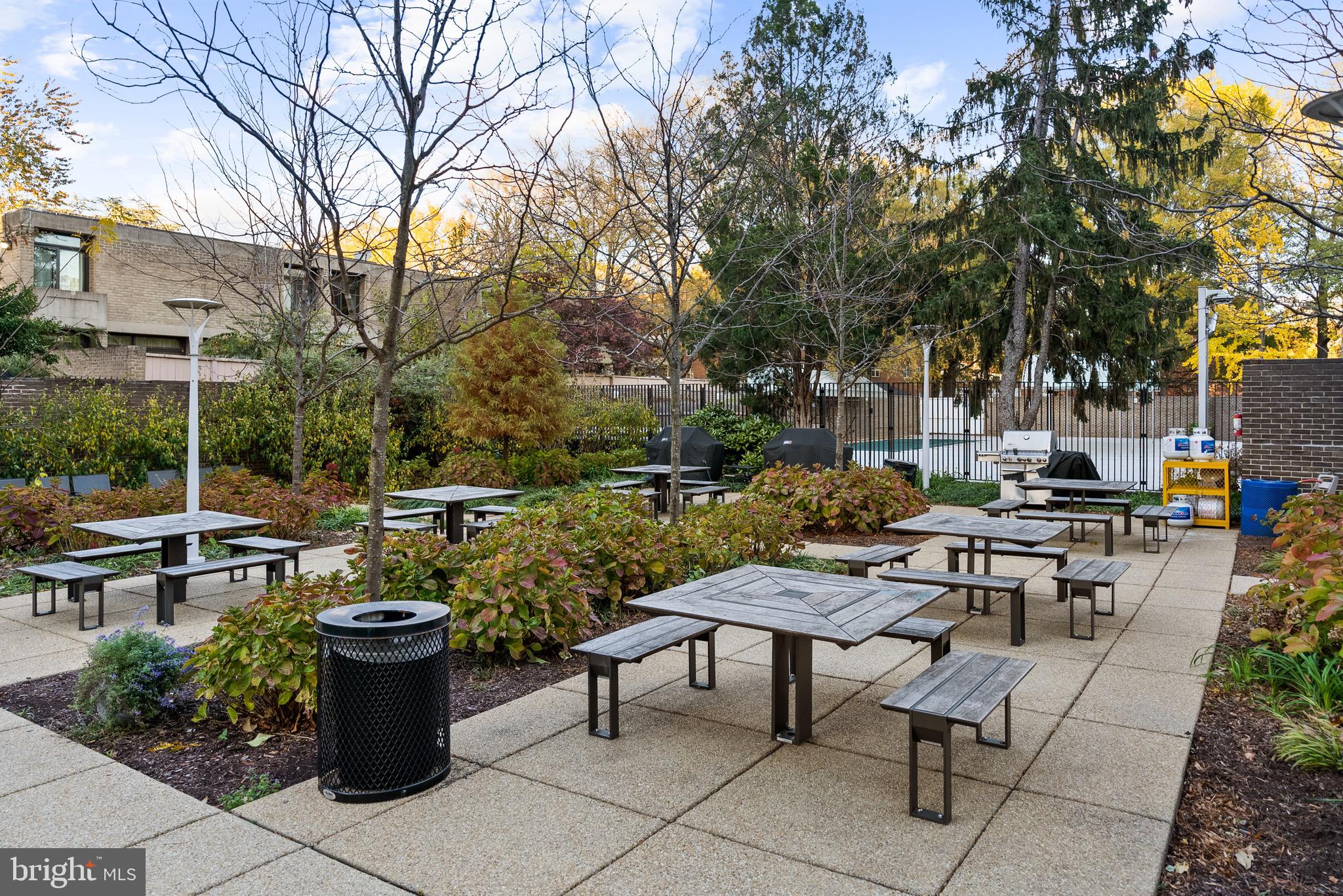 1301 Delaware Avenue Southwest, Unit N108 Washington, DC 20024 - Photo 35 of 39 a view of a patio with table and chairs potted plants and a large tree