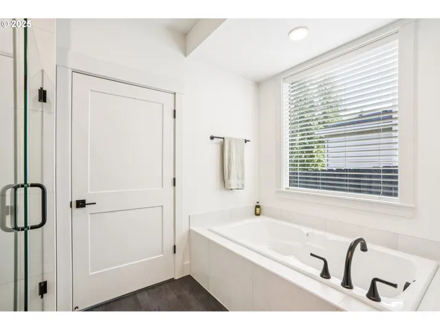a bathroom with a tub sink and mirror