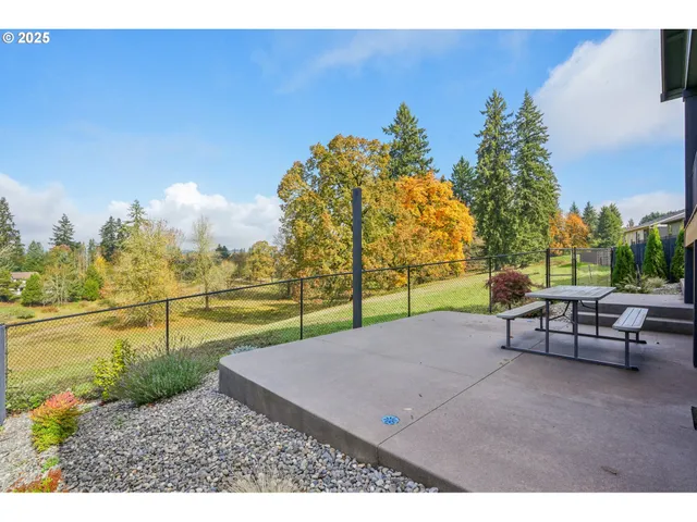 a backyard of a house with barbeque oven table and chairs