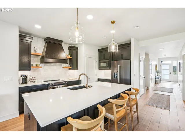 a kitchen with a table chairs refrigerator and microwave