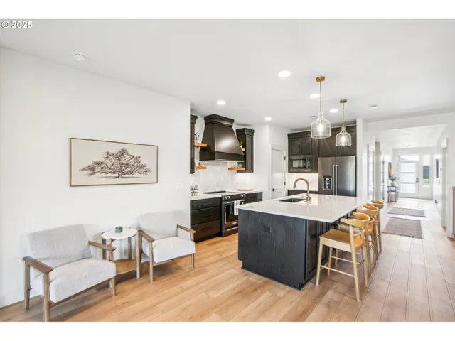 a living room with stainless steel appliances kitchen island granite countertop furniture and a view of kitchen