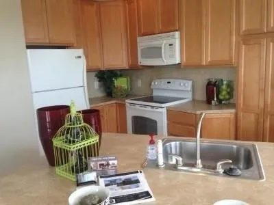 a kitchen with a refrigerator sink and cabinets