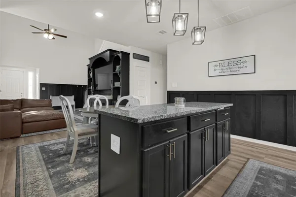 a kitchen with granite countertop a sink cabinets and stainless steel appliances