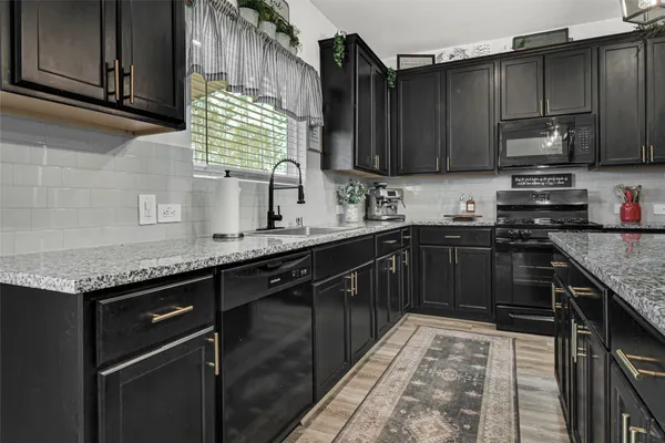 a kitchen with stainless steel appliances granite countertop a sink stove and microwave