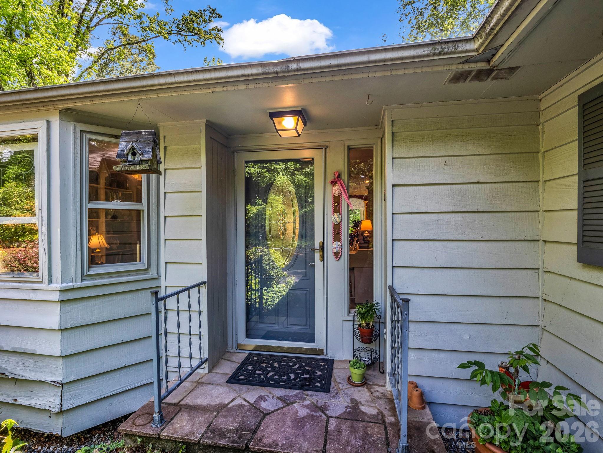 57 Tate Lane Tryon, NC 28782 - Photo 2 of 48 a view of a house with a potted plant and floor to ceiling window and potted plants