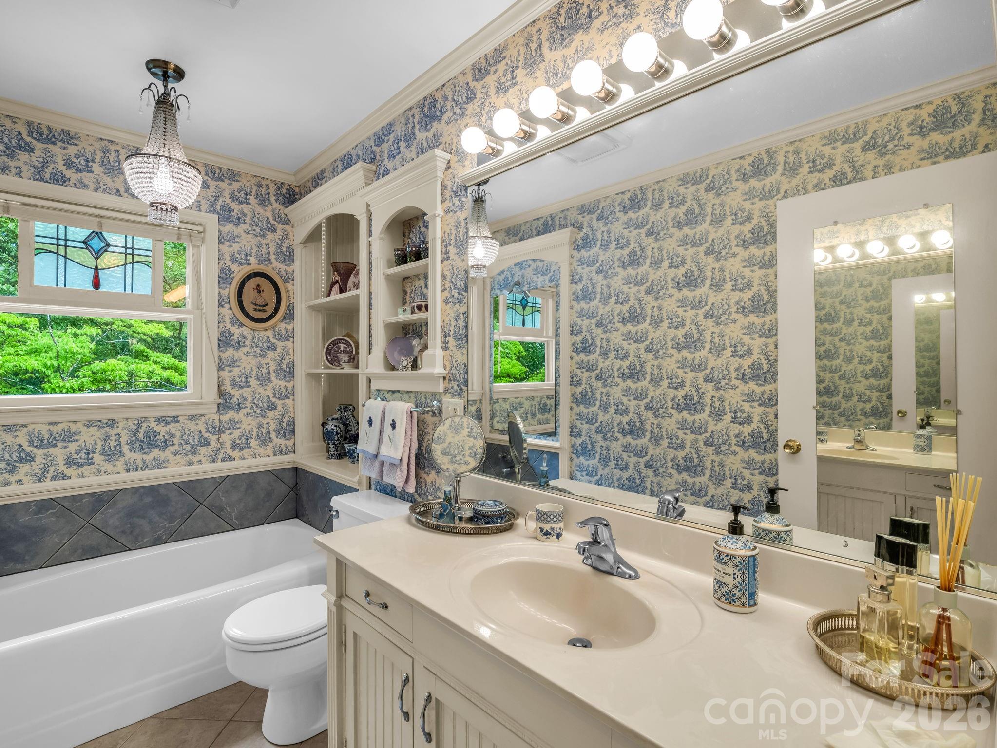 57 Tate Lane Tryon, NC 28782 - Photo 21 of 48 a bathroom with a sink a toilet a mirror a bathtub and next to a window