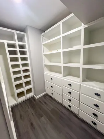 a view of walk in closet with empty racks