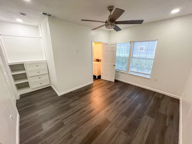 a view of a livingroom with wooden floor and a ceiling fan