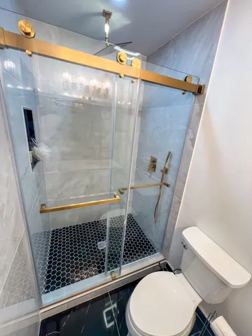 a bathroom with a toilet and a shower