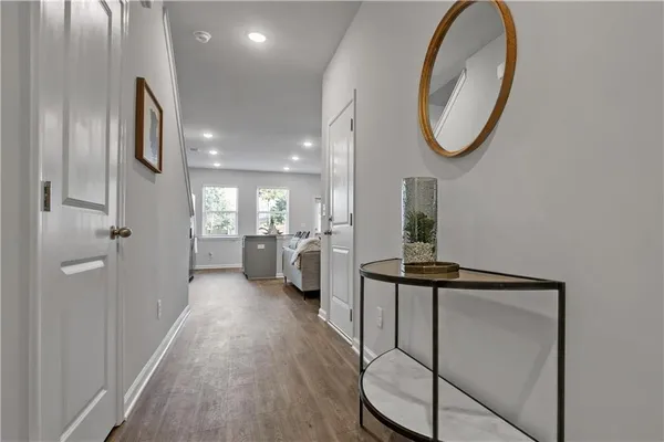 a view of a hallway with wooden floor windows and a bathroom