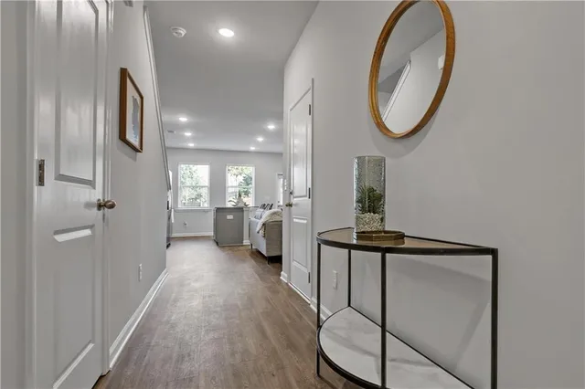 a view of a hallway with wooden floor windows and a bathroom