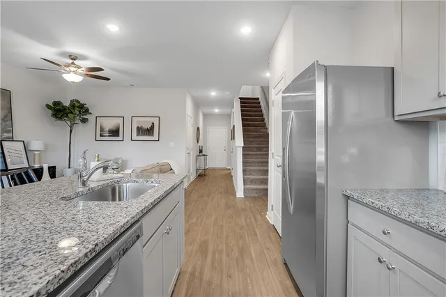 a kitchen with granite countertop a sink and refrigerator