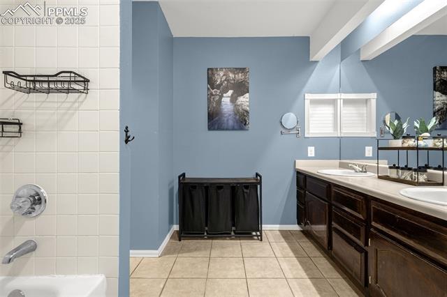 4990 Castledown Road Colorado Springs, CO 80917 - Photo 19 of 37 Full bath with double vanity, tile patterned flooring, shower / bathtub combination, and a sink