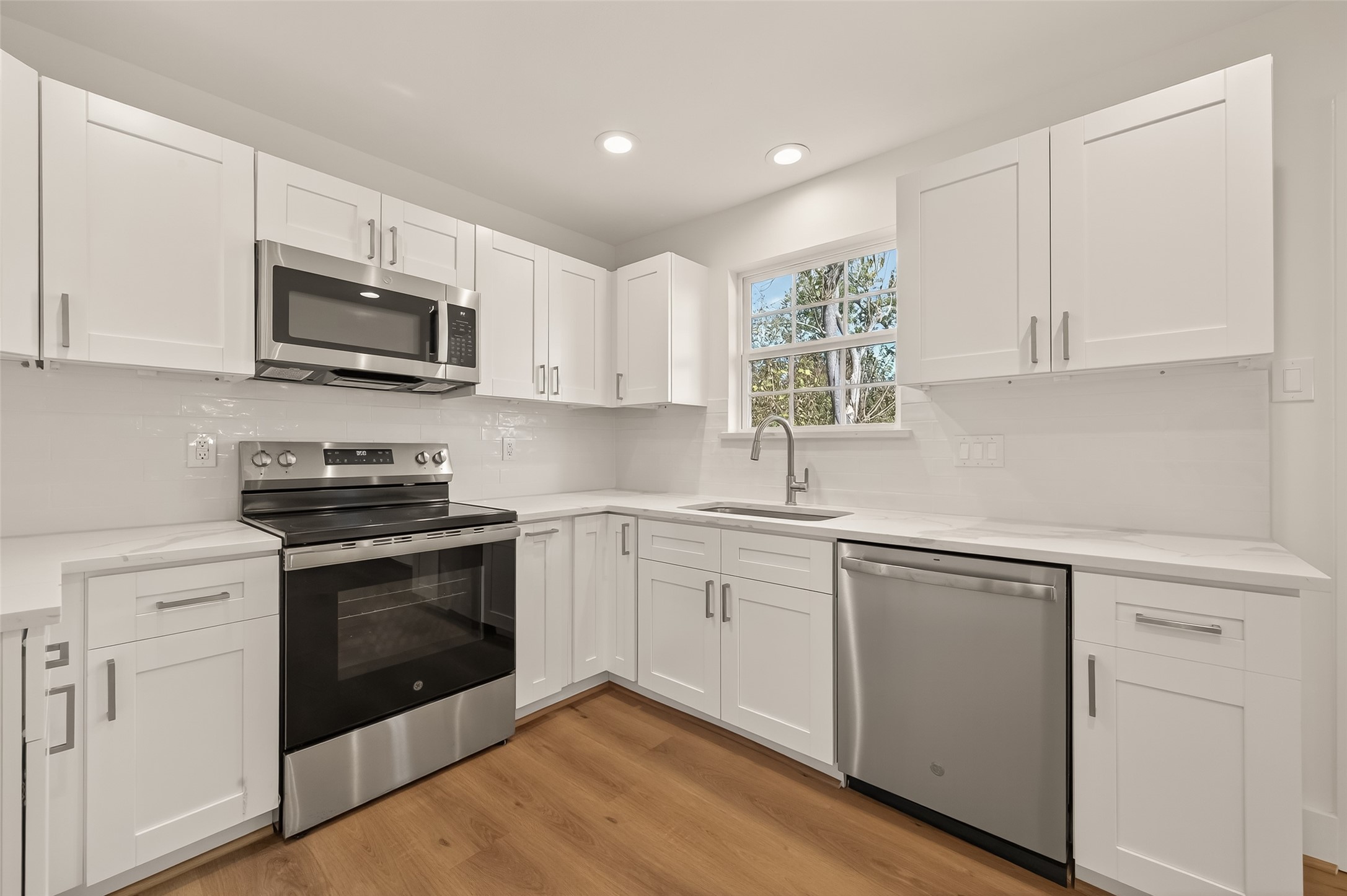 2723 Castledale Drive Houston, TX 77093 - Photo 14 of 38 a kitchen with cabinets stainless steel appliances and wooden floor
