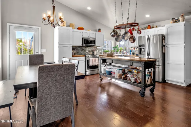 a view of kitchen with stainless steel appliances granite countertop refrigerator microwave and stove top oven