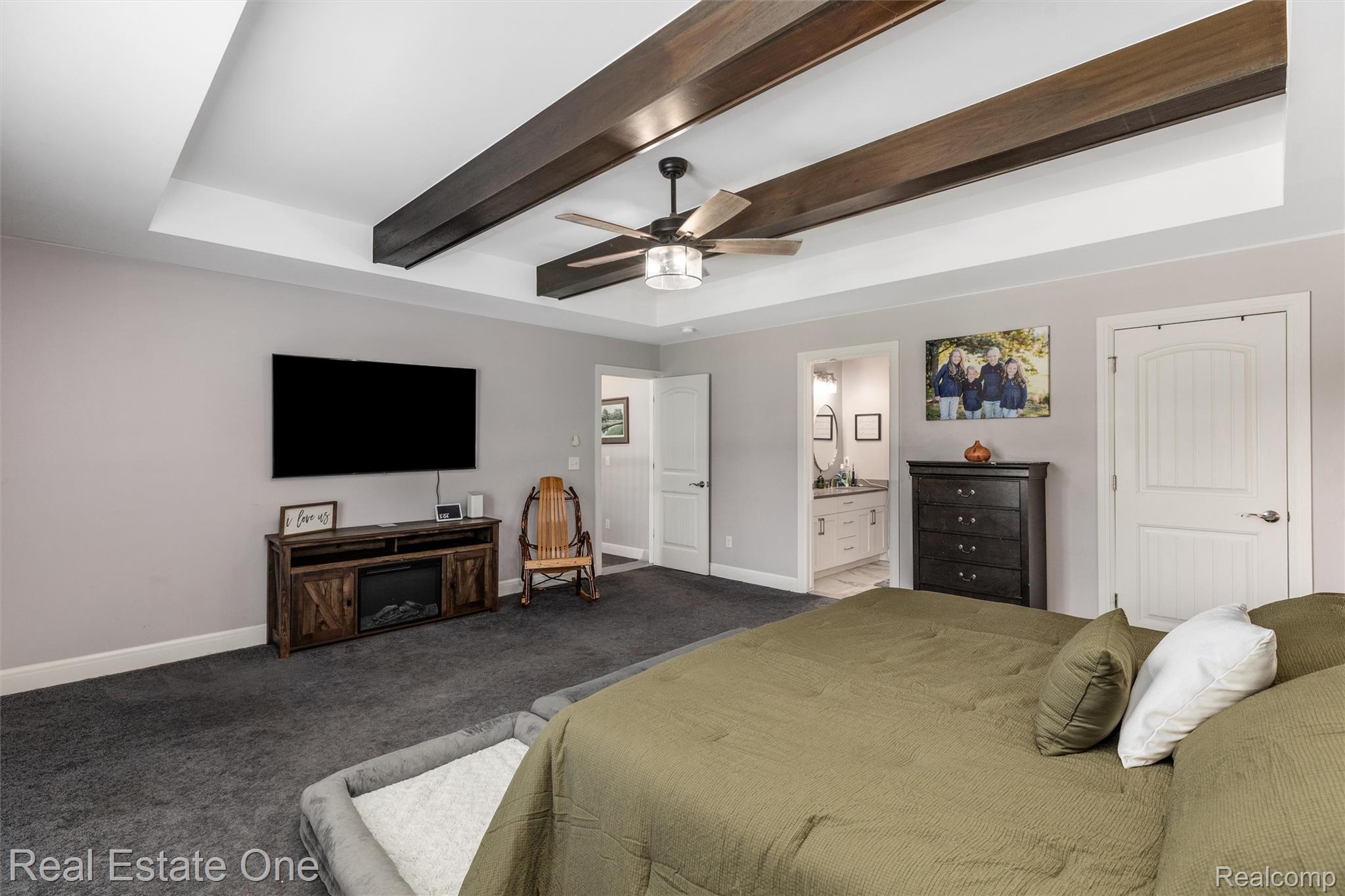 2983 28 Mile Road Washington, MI 48094 - Photo 27 of 54 Room featuring tray ceiling with exposed wood-finish beams, ceiling fan light fixture, and gray carpeting