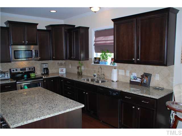 6736 Rex Road Holly Springs, NC 27540 - Photo 7 of 25 What a loaded kitchen! Granite, S S appliances, tile backsplash, and hardwood floors!