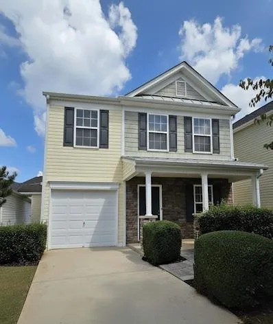 a front view of a house with a garden