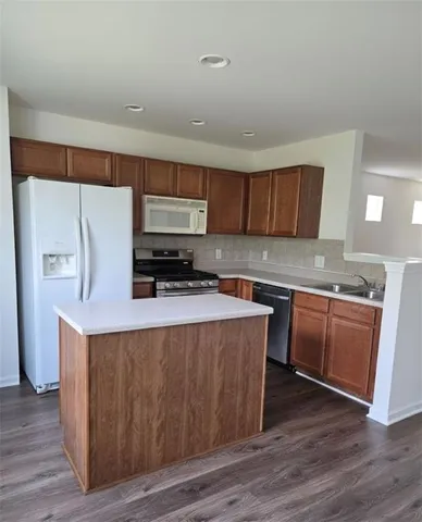 a kitchen with stainless steel appliances a refrigerator and a stove top oven