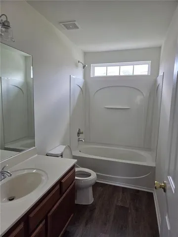 a bathroom with a sink a toilet and a large mirror