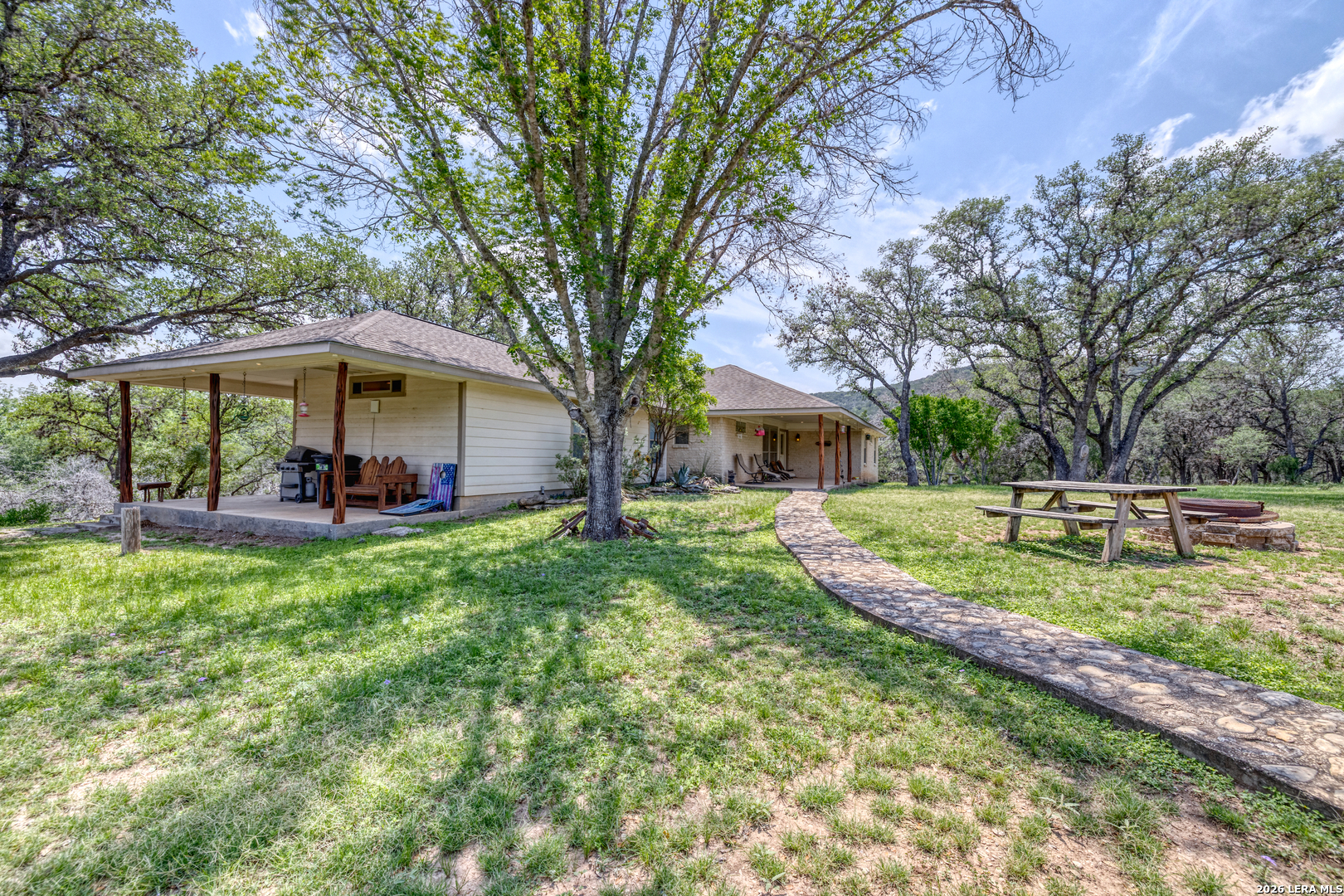 a view of a house with backyard and trees