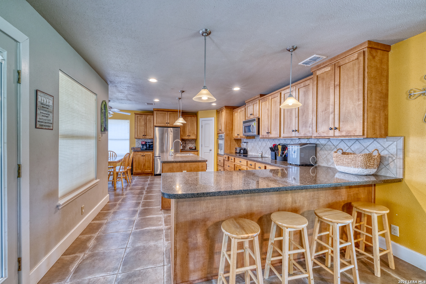 270 Robinson Road Concan, TX 78838 - Photo 20 of 50 a view of a kitchen with kitchen island granite countertop a large window cabinets and stainless steel appliances
