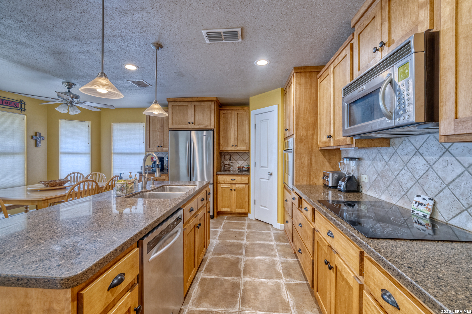 270 Robinson Road Concan, TX 78838 - Photo 22 of 50 a kitchen with stainless steel appliances granite countertop a sink a stove and a wooden cabinets