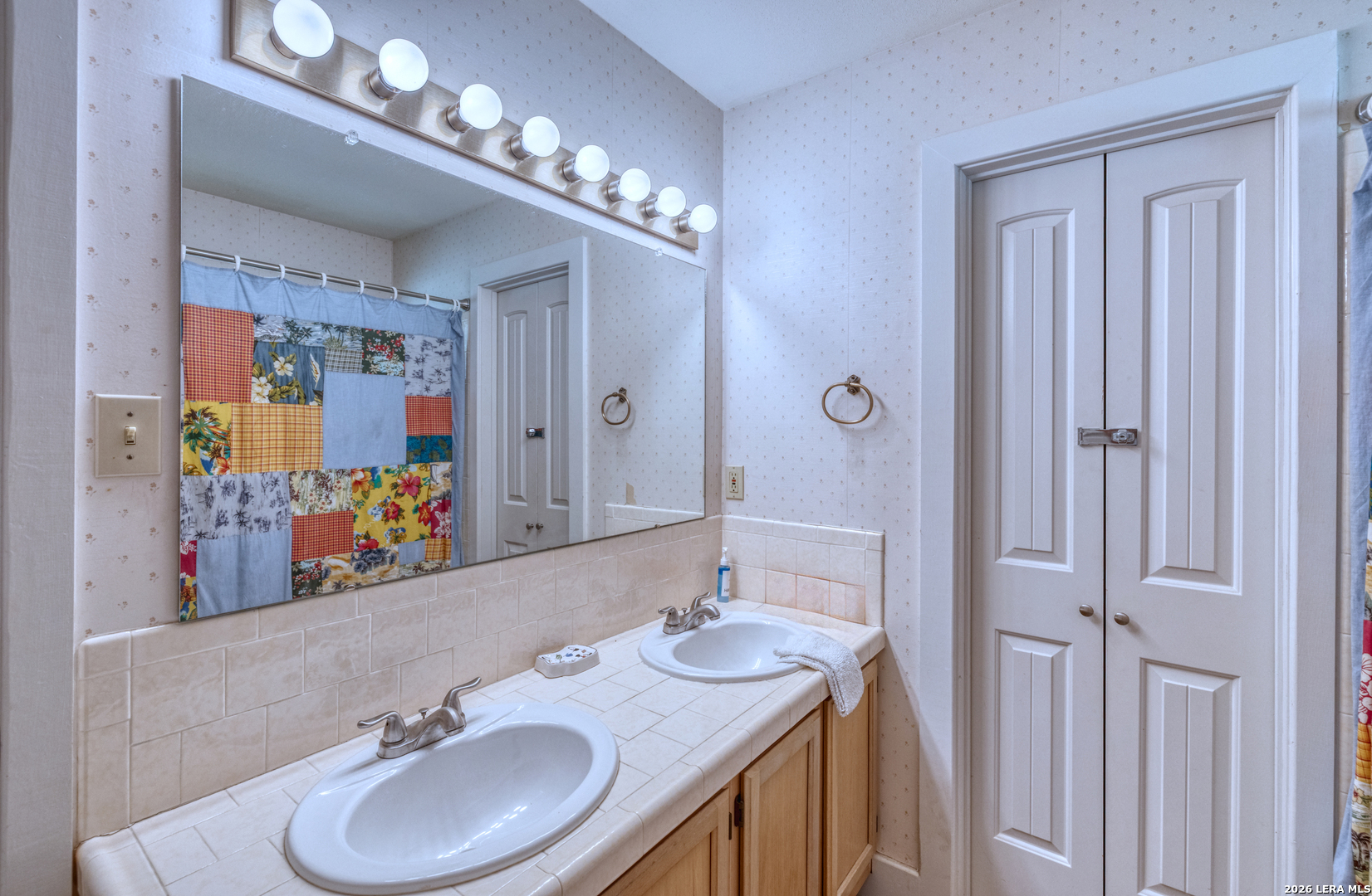 270 Robinson Road Concan, TX 78838 - Photo 34 of 50 a bathroom with double vanity sinks a vanity a lamp and a mirror