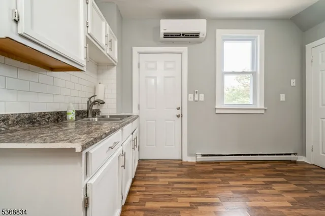 a bathroom with a granite countertop sink and a window