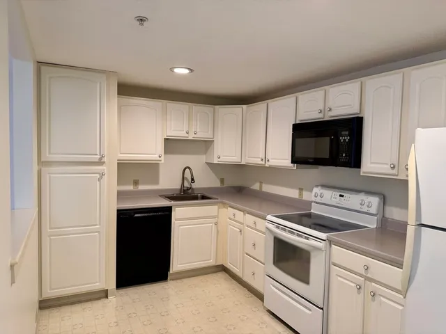 a kitchen with stainless steel appliances granite countertop a sink and a microwave