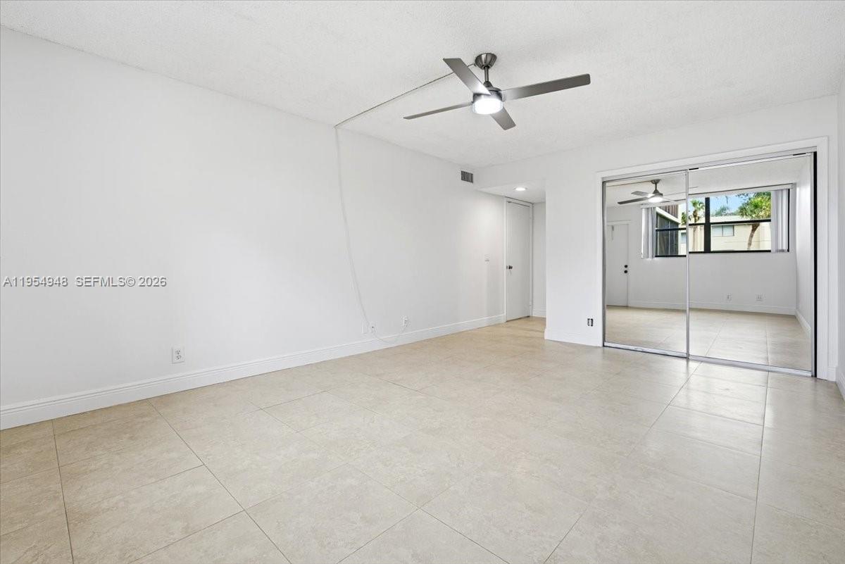 491 Racquet Club Road, Unit 107 Weston, FL 33326 - Photo 13 of 34 an empty room with ceiling fan and windows