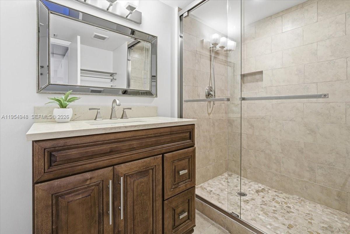 491 Racquet Club Road, Unit 107 Weston, FL 33326 - Photo 21 of 34 a bathroom with a granite countertop sink a mirror and a shower