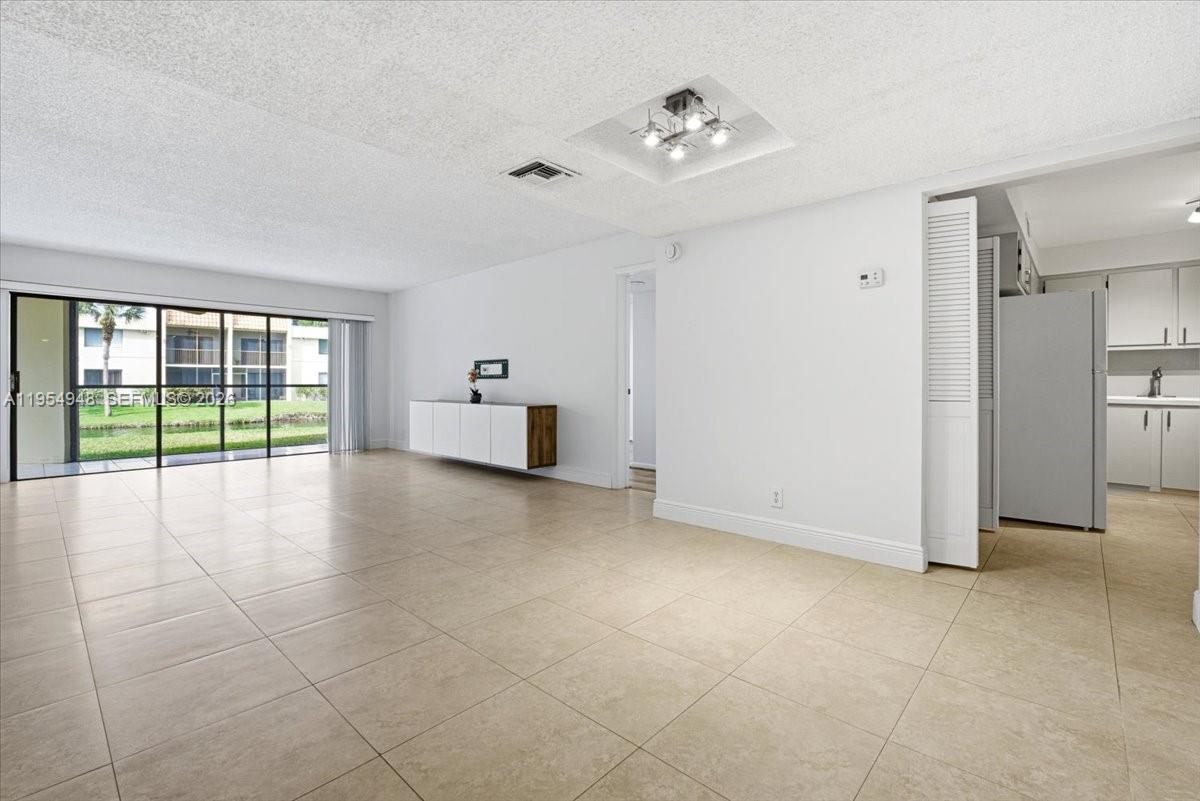 491 Racquet Club Road, Unit 107 Weston, FL 33326 - Photo 6 of 34 a view of empty room with floor to ceiling window and an empty room