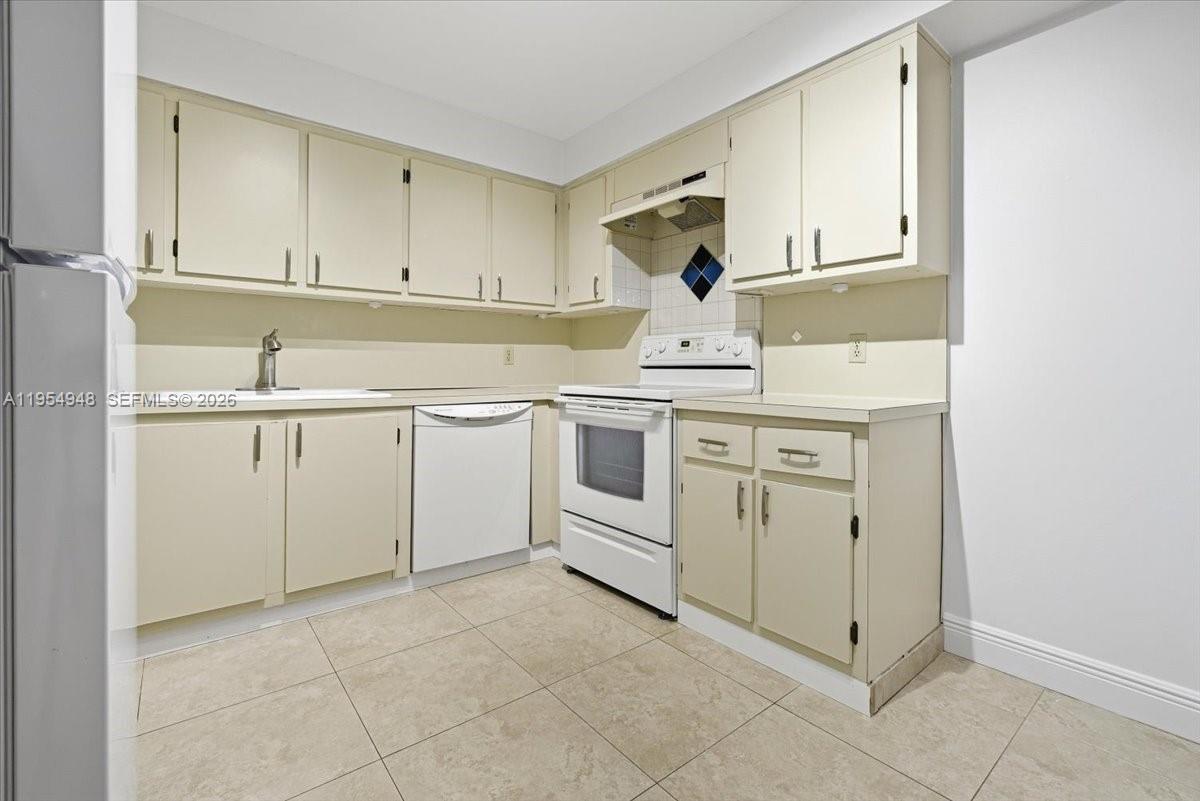 491 Racquet Club Road, Unit 107 Weston, FL 33326 - Photo 10 of 34 a kitchen with white cabinets and sink