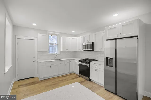 a kitchen with white cabinets sink and stainless steel appliances