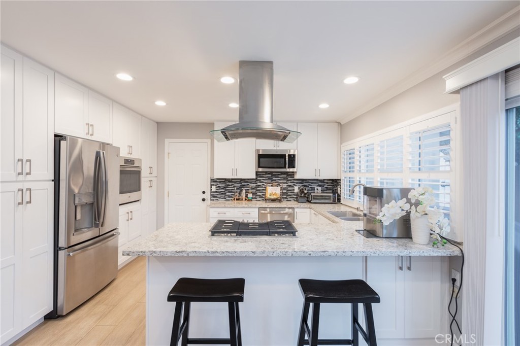 484 Traverse Drive Costa Mesa, CA 92626 - Photo 24 of 30 a kitchen with stainless steel appliances kitchen island granite countertop a refrigerator and a stove top oven